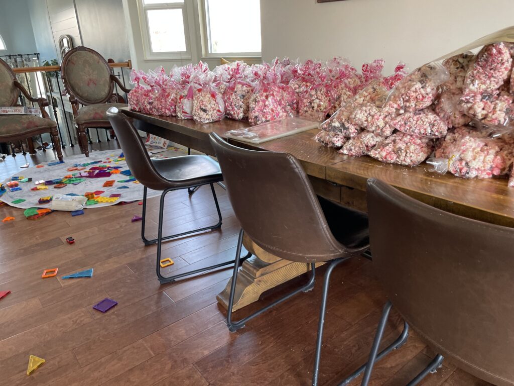 The Valentines popcorn bags piling up.  Bigger kids were working on popcorn while the little kids played with magnets.